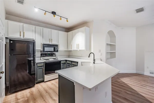 a kitchen with kitchen island a sink appliances and cabinets