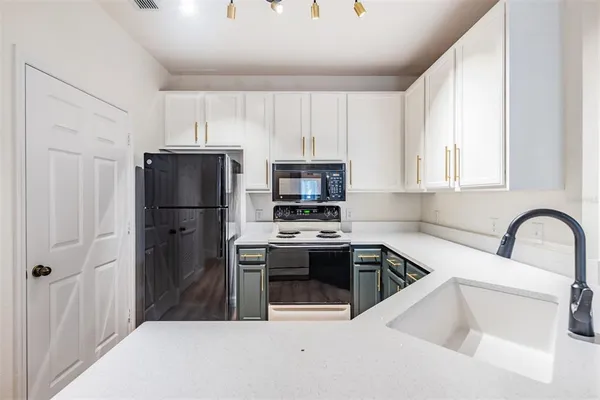 a kitchen with kitchen island a stove a microwave and a refrigerator