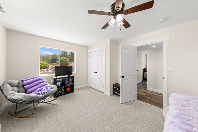 2591 East Washington Dam Road Washington, UT 84780 - Photo 34 of 67 Carpeted room featuring a ceiling fan with light, a window with outdoor scenery, and two white paneled doors