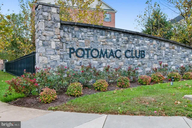 a sign board with buildings in the background