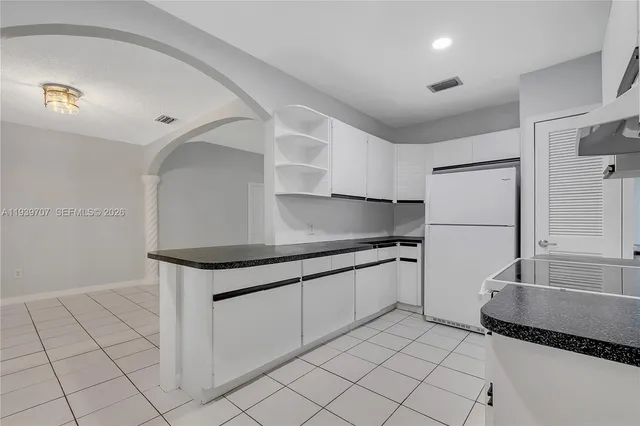 a kitchen with granite countertop a sink and a refrigerator