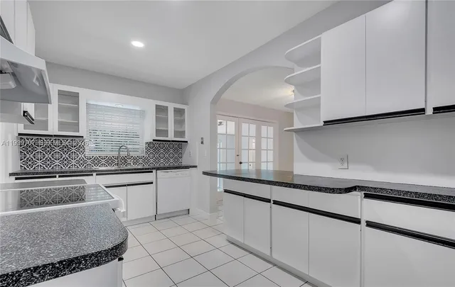 a kitchen with granite countertop stainless steel appliances a sink and cabinets