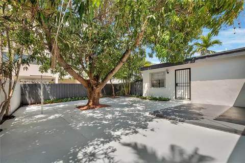 a tree in front of a white house