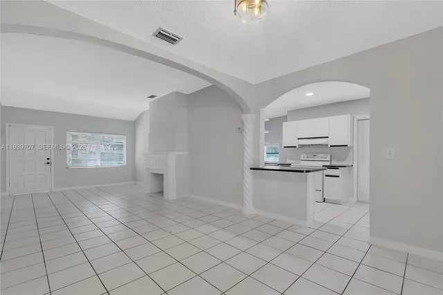 a kitchen with white cabinets a sink and appliances