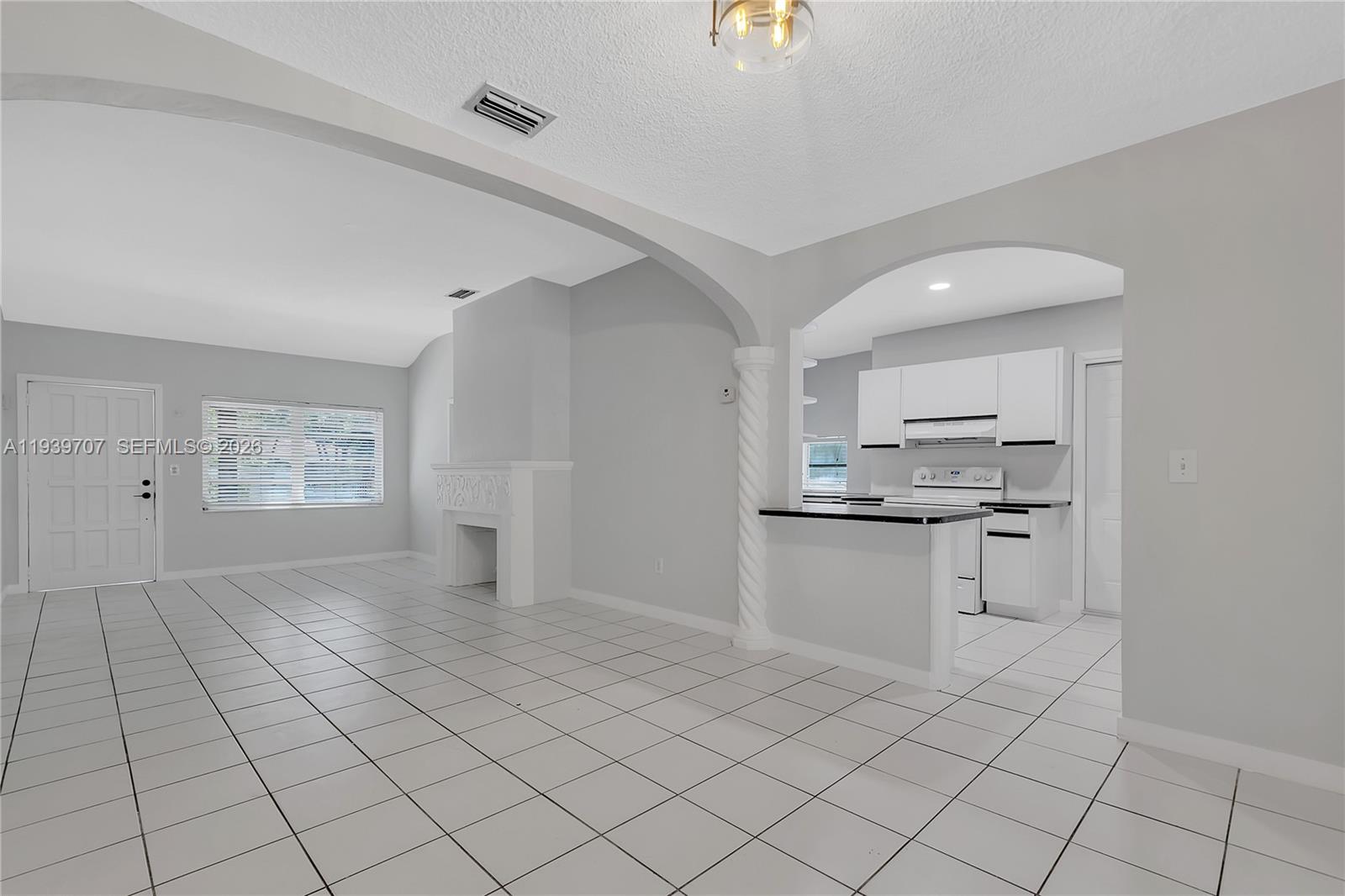 2327 Southwest 22nd Terrace, Unit FRONT Miami, FL 33145 - Photo 7 of 29 a kitchen with white cabinets a sink and appliances