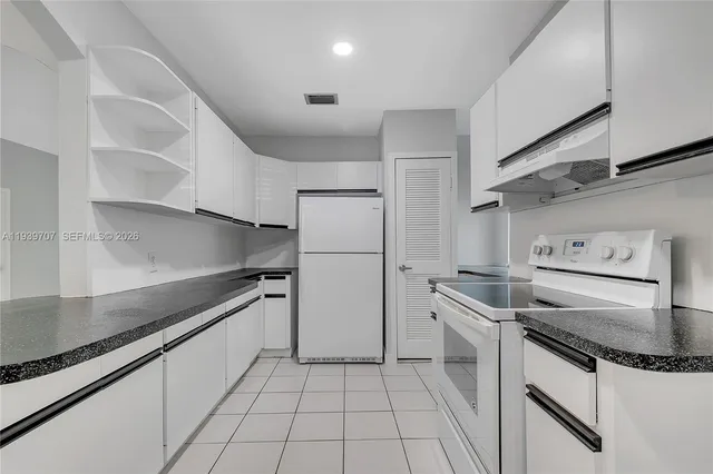 a kitchen with white cabinets and white appliances