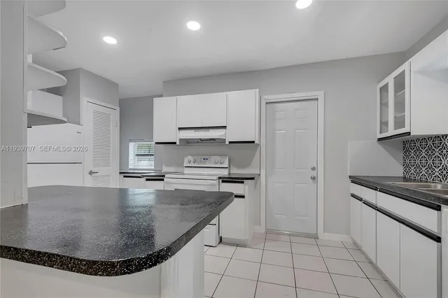 a kitchen with stainless steel appliances granite countertop a sink stove and cabinets
