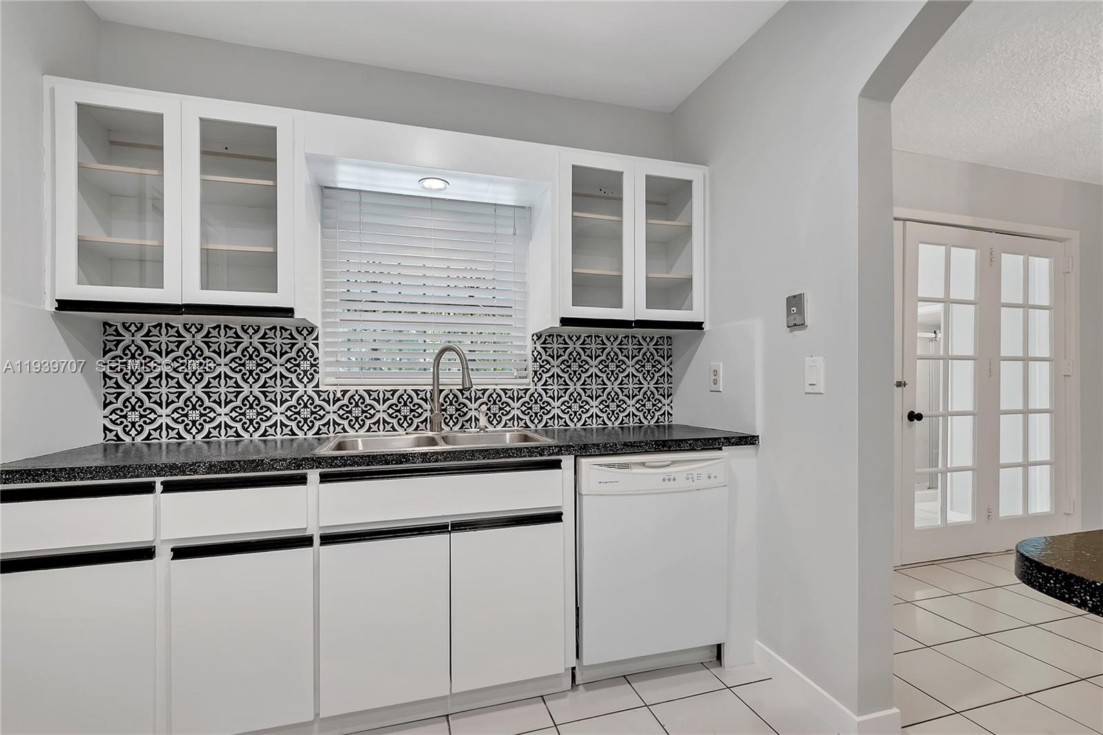 2327 Southwest 22nd Terrace, Unit FRONT Miami, FL 33145 - Photo 10 of 29 a kitchen with granite countertop white cabinets and sink
