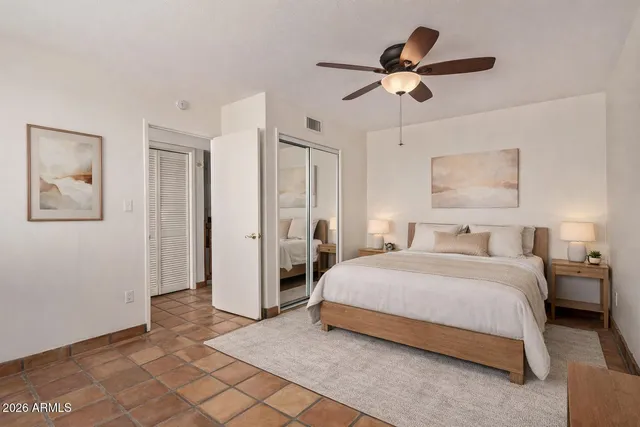 a spacious bedroom with a bed and a chandelier