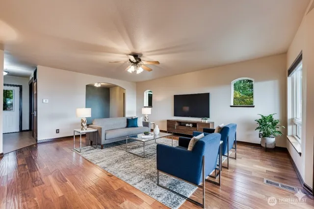 a living room with furniture flat screen tv and wooden floor