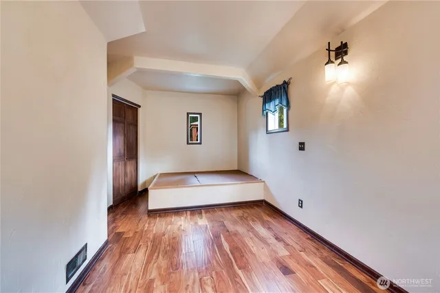 a room with a wooden floor and a ceiling fan
