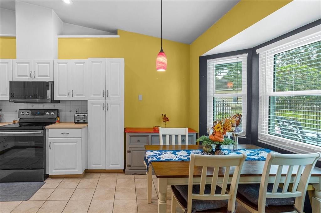 7203 Northwest 121st Avenue Alachua, FL 32615 - Photo 11 of 37 a kitchen with stainless steel appliances kitchen island granite countertop a dining table and chairs
