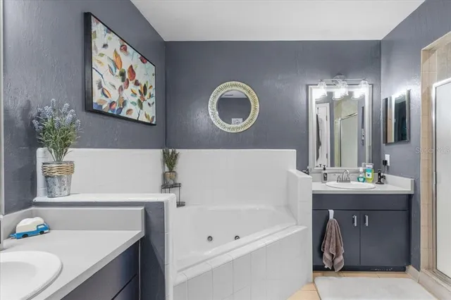 a bathroom with a tub sink and mirror