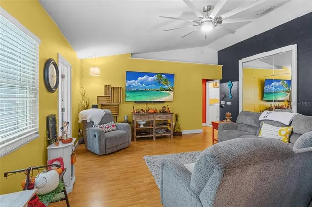 a living room with furniture kitchen view and a large window