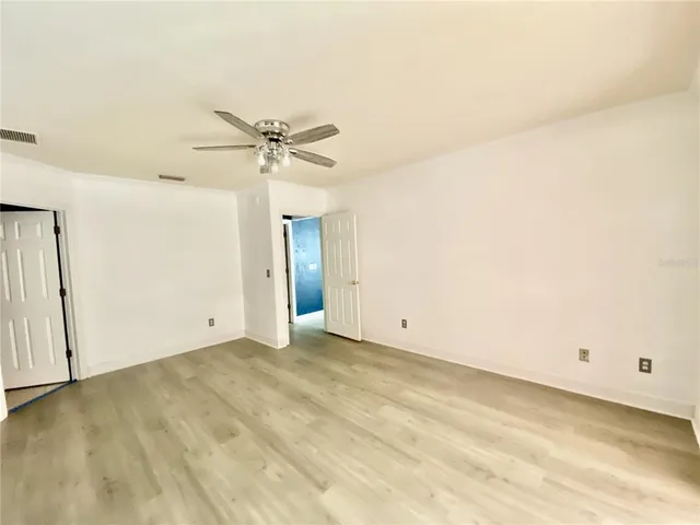 an empty room with a ceiling fan and a window