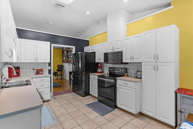 a kitchen with stainless steel appliances a refrigerator sink and microwave