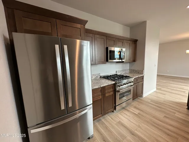 a bathroom with a granite countertop sink a light fixture and a mirror