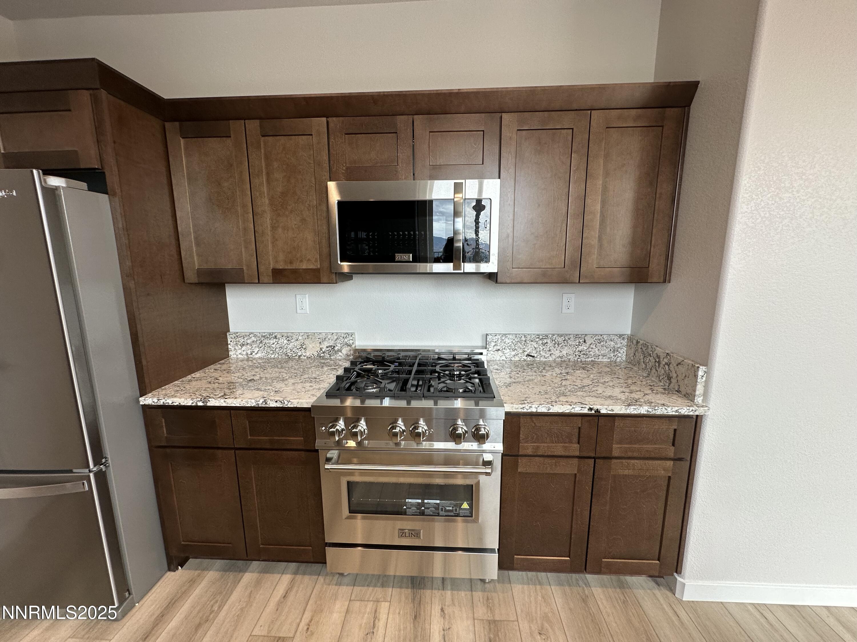 1180 Arrastra Road Reno, NV 89512 - Photo 15 of 48 a kitchen with granite countertop a stove and a refrigerator