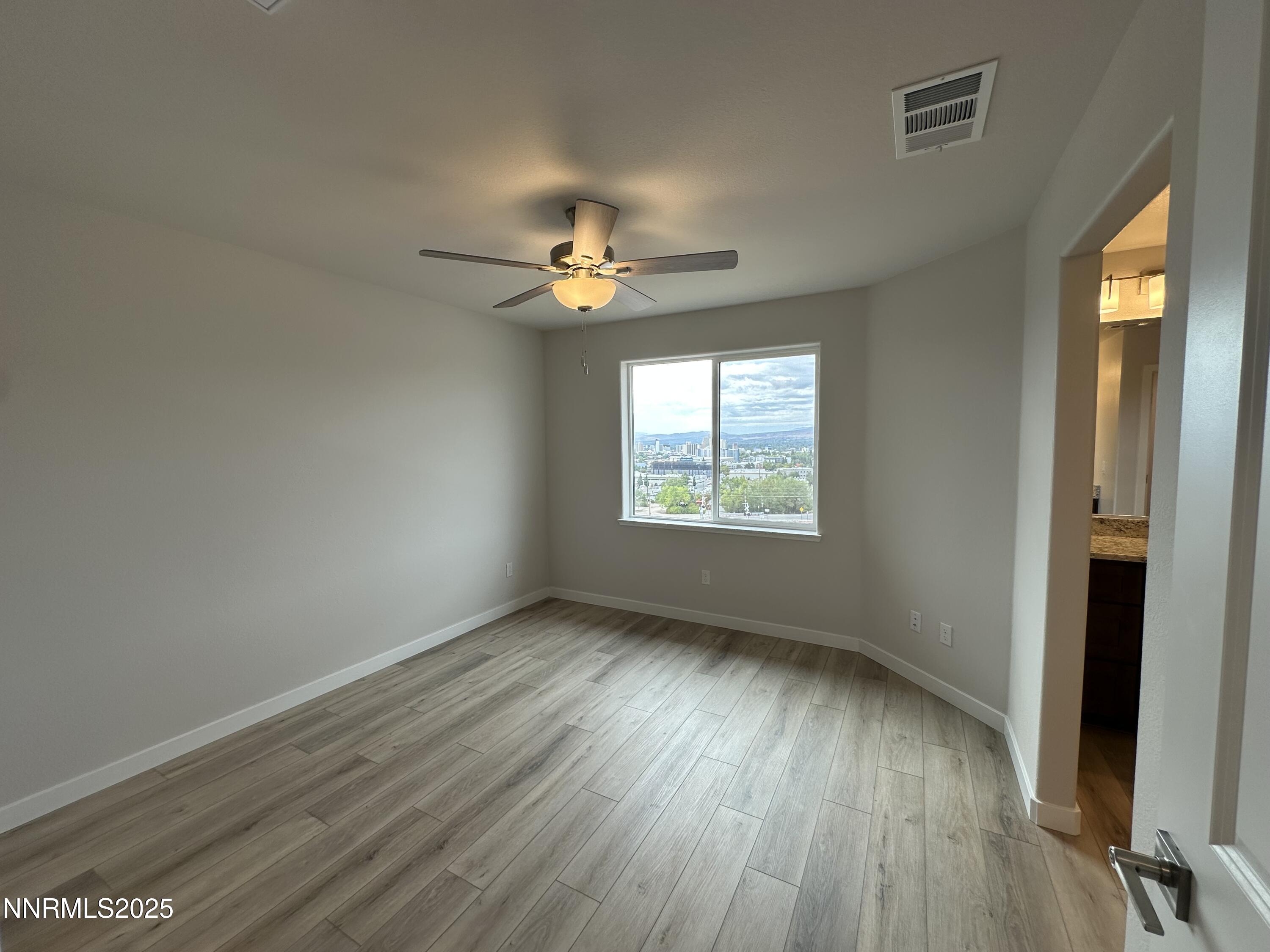 1180 Arrastra Road Reno, NV 89512 - Photo 18 of 48 an empty room with wooden floor and windows