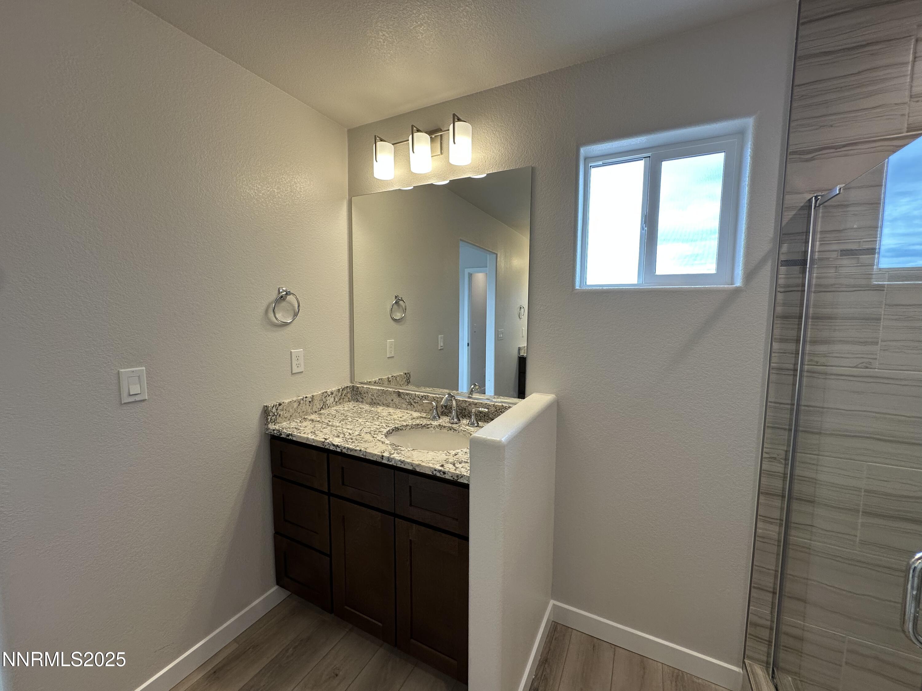 1180 Arrastra Road Reno, NV 89512 - Photo 25 of 48 a bathroom with a granite countertop sink a light fixture and a mirror