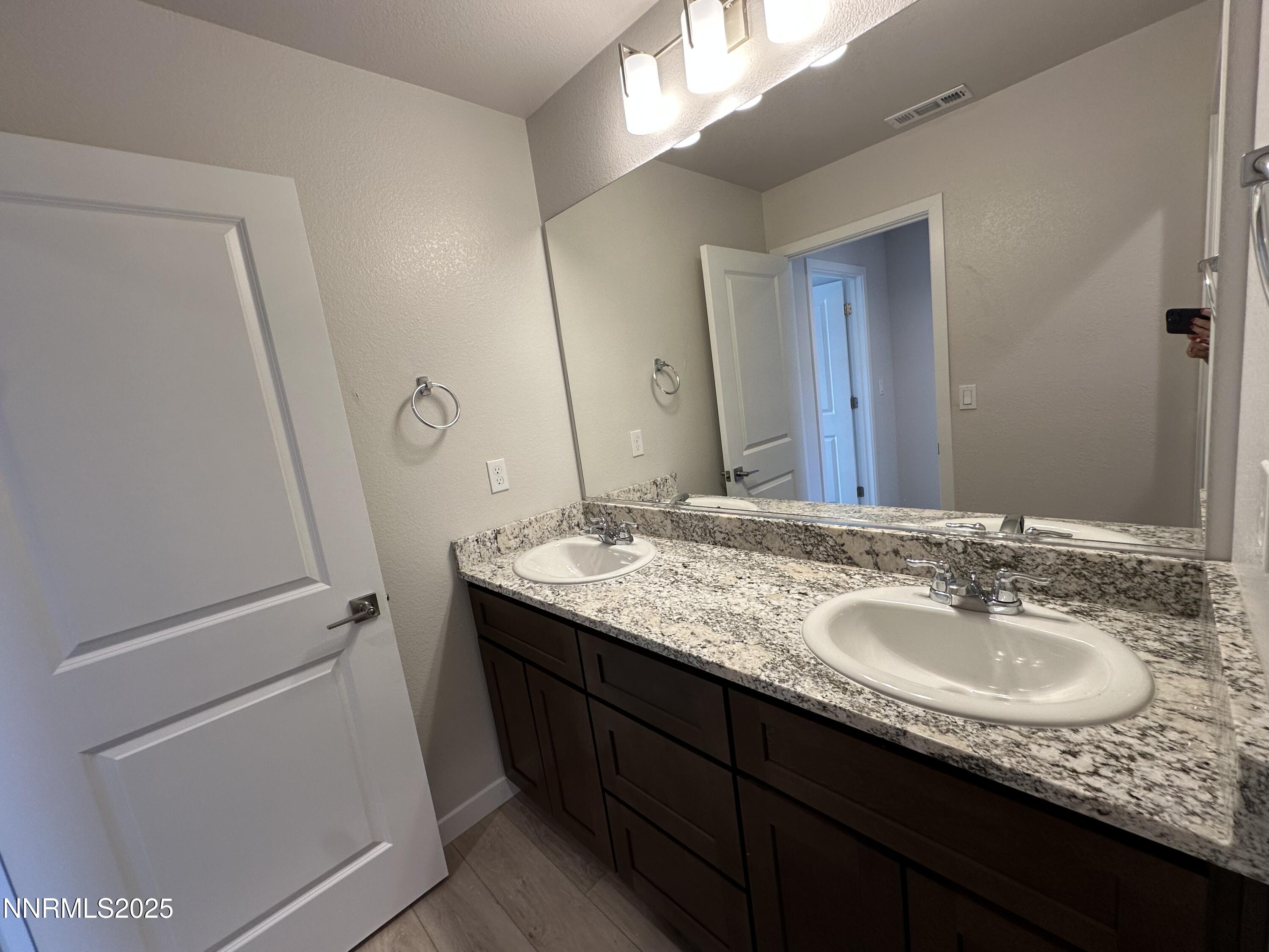 1180 Arrastra Road Reno, NV 89512 - Photo 37 of 48 a bathroom with a granite countertop sink and a mirror
