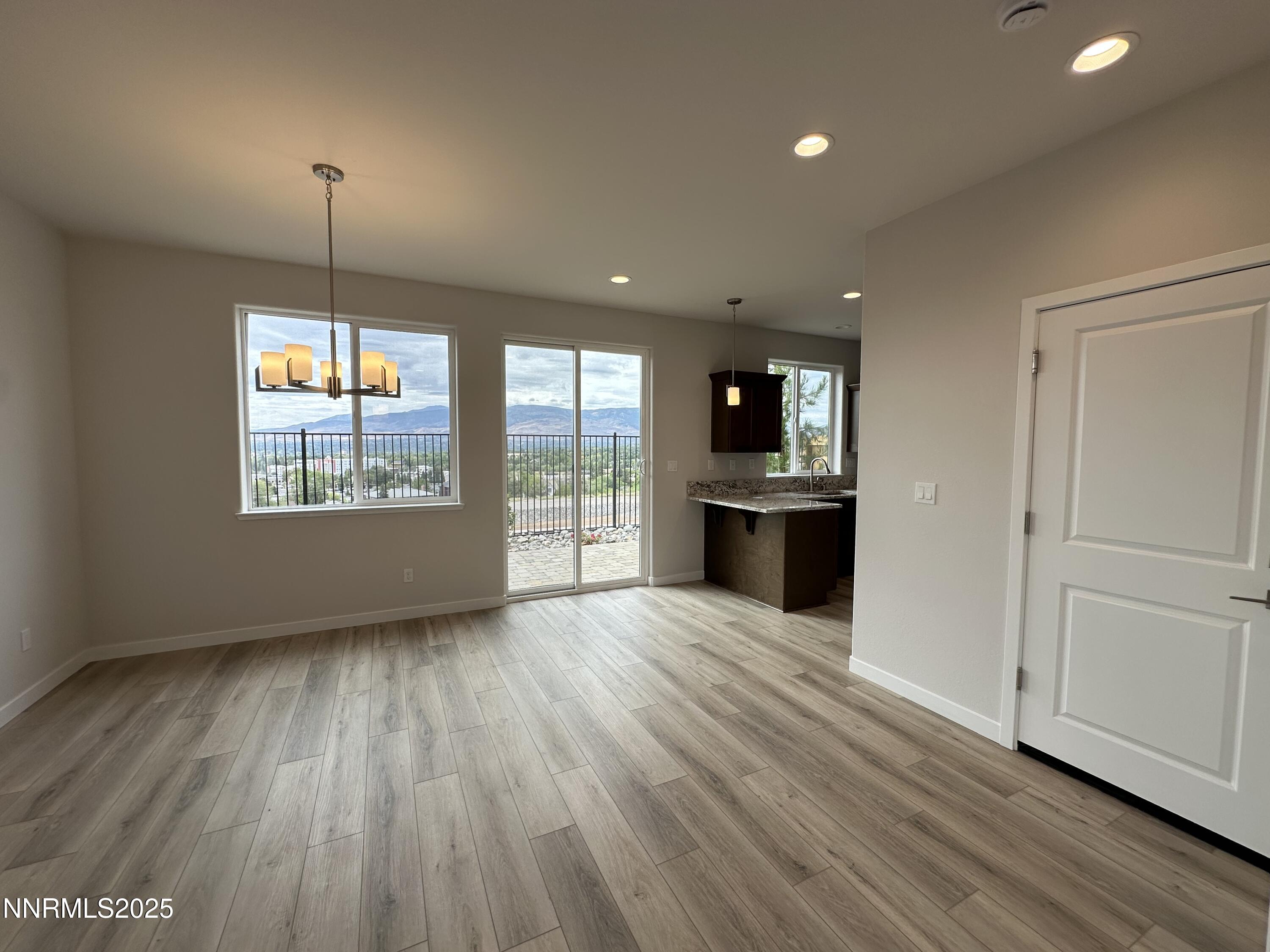 1180 Arrastra Road Reno, NV 89512 - Photo 8 of 48 an empty room with wooden floor and windows