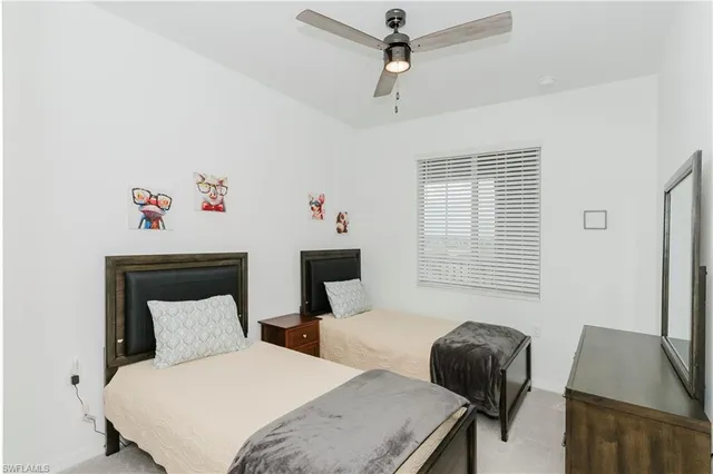 a bedroom with a bed and a chair with the potted plant