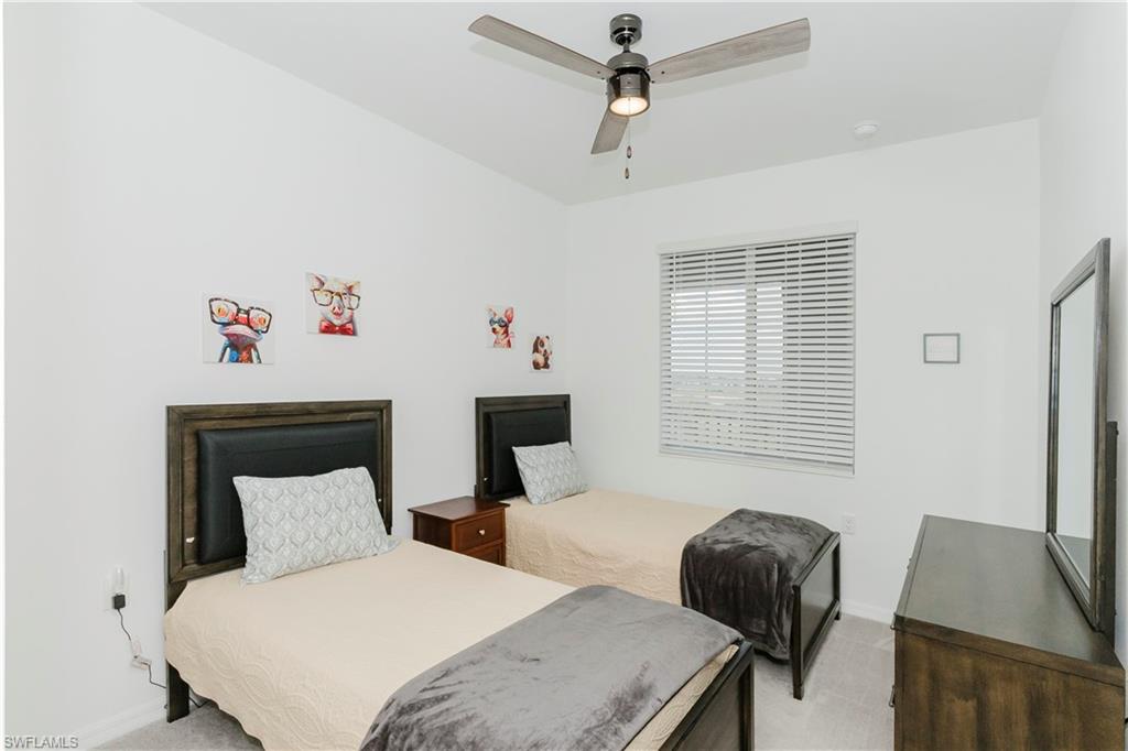 6034 National Boulevard, Unit 542 Ave Maria, FL 34142 - Photo 11 of 36 a bedroom with a bed and a chair with the potted plant