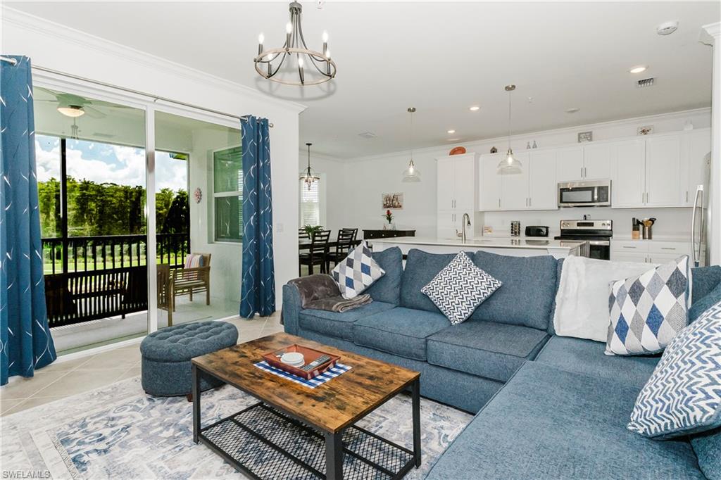 6034 National Boulevard, Unit 542 Ave Maria, FL 34142 - Photo 3 of 36 a living room with furniture and a chandelier