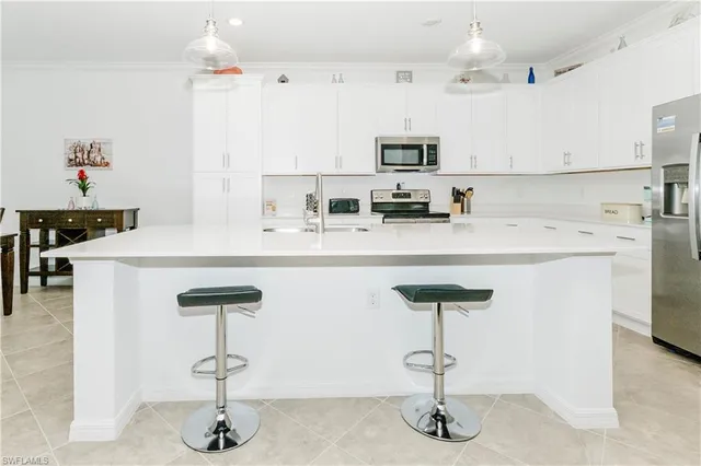 a kitchen with stainless steel appliances a sink cabinets and wooden floor