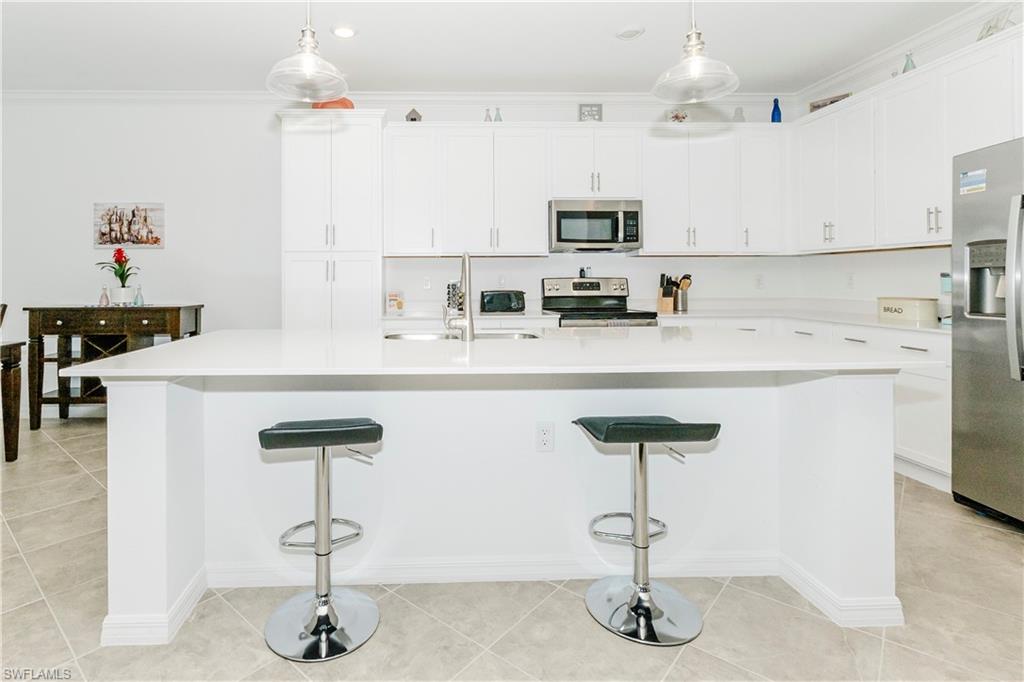 6034 National Boulevard, Unit 542 Ave Maria, FL 34142 - Photo 4 of 36 a kitchen with stainless steel appliances a sink cabinets and wooden floor