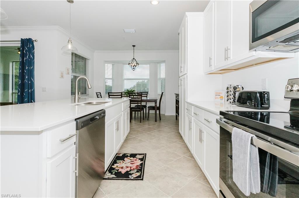 6034 National Boulevard, Unit 542 Ave Maria, FL 34142 - Photo 5 of 36 a kitchen with cabinets and chairs