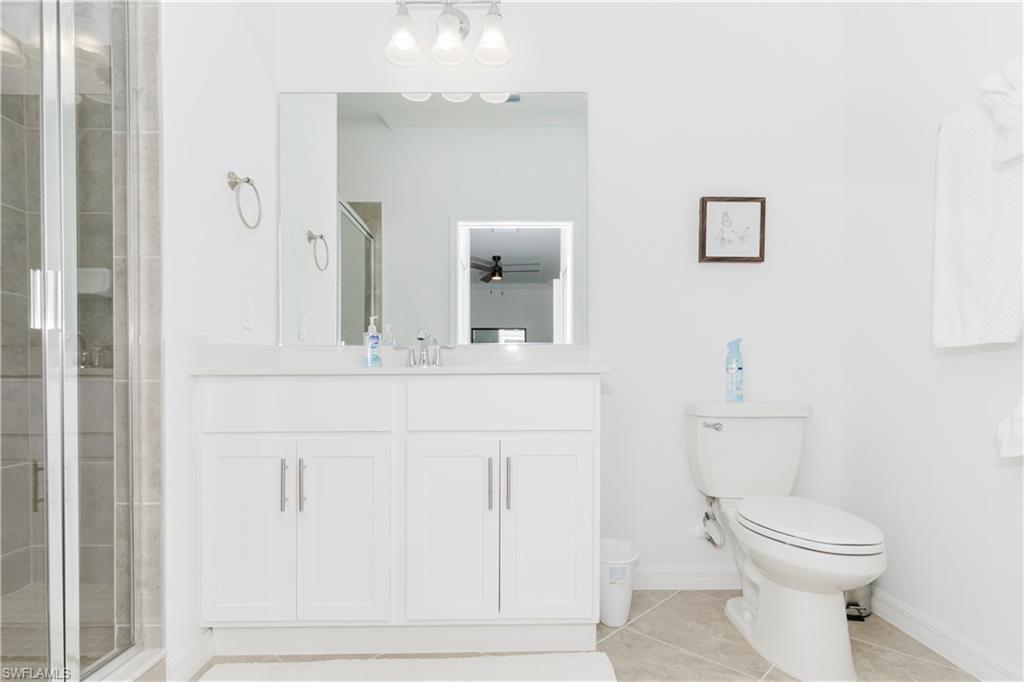 6034 National Boulevard, Unit 542 Ave Maria, FL 34142 - Photo 9 of 36 a bathroom with a toilet a sink and mirror