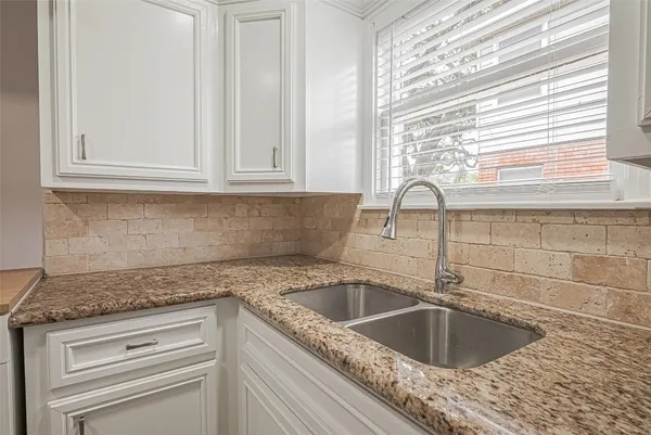 a kitchen with granite countertop a sink and a window