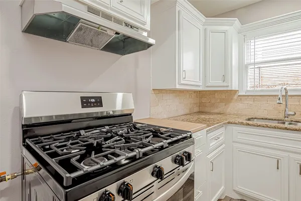 a stove top oven sitting inside of a kitchen