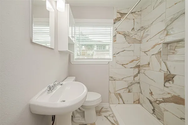 a bathroom with a sink toilet and shower
