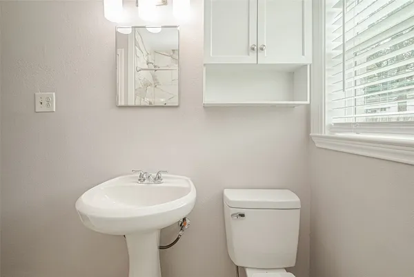 a bathroom with a toilet sink and mirror