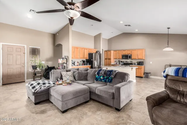 a living room with furniture kitchen view and a chandelier