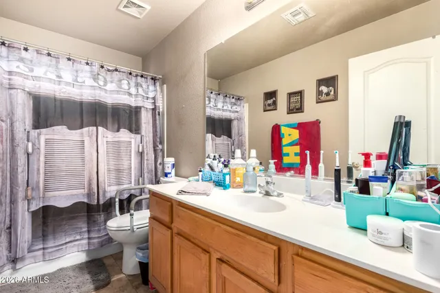 a bathroom with a sink vanity mirror and toilet