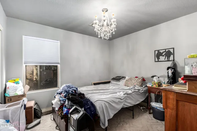 a bedroom with a bed and a chandelier