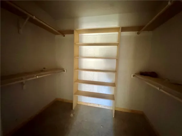 a view of walk in closet with empty racks