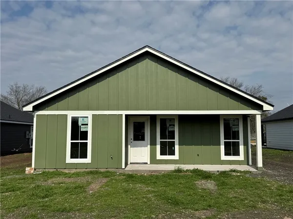 a view of backyard with large windows and plants