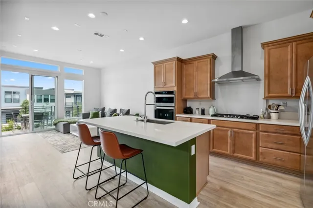 a kitchen with stainless steel appliances granite countertop a stove top oven a sink dishwasher and white cabinets with wooden floor