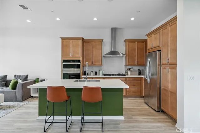 a kitchen with stainless steel appliances a sink a stove a refrigerator and cabinets