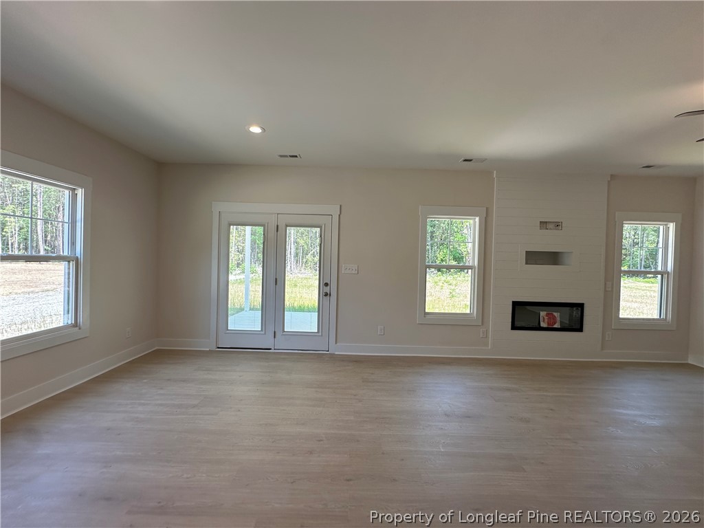 2908 Calloway Road Raeford, NC 28376 - Photo 11 of 25 an empty room with wooden floor and windows