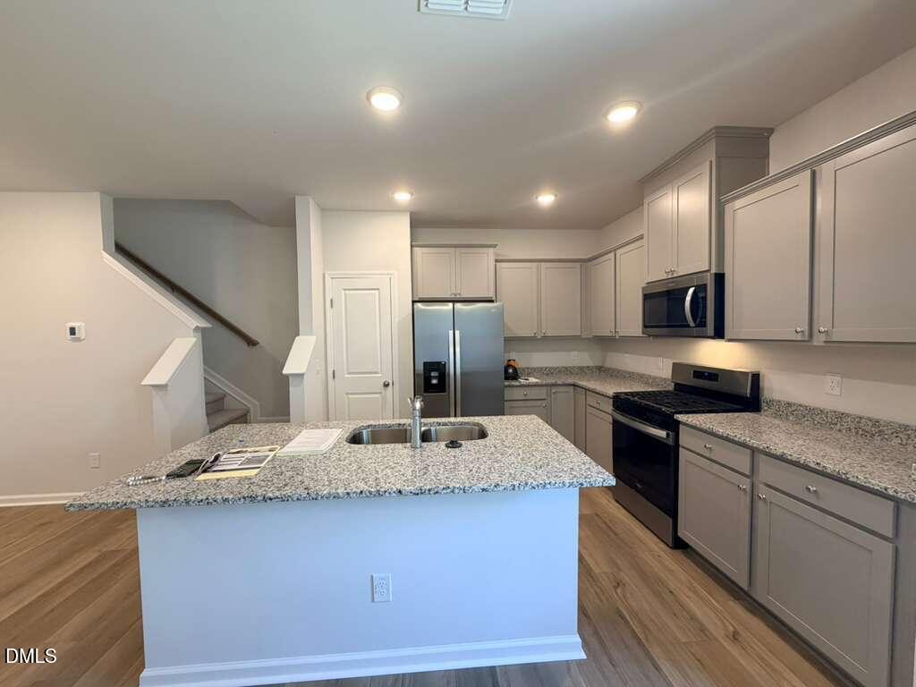 5024 Reader Way Durham, NC 27703 - Photo 8 of 26 a kitchen with stainless steel appliances granite countertop a sink stove and refrigerator