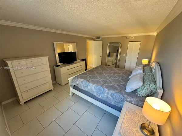 a bedroom with a bed and dresser with mirror