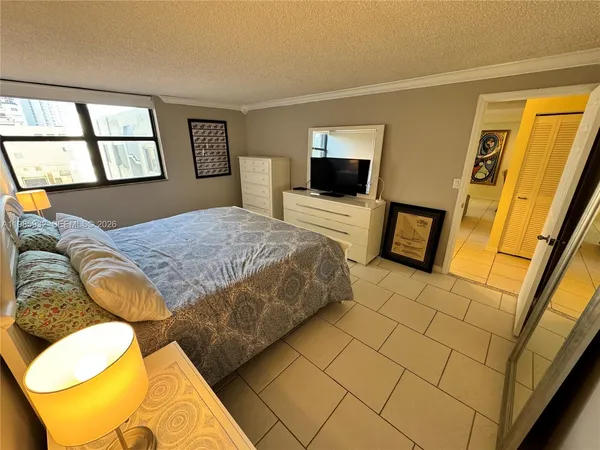 a bedroom with a bed and a television