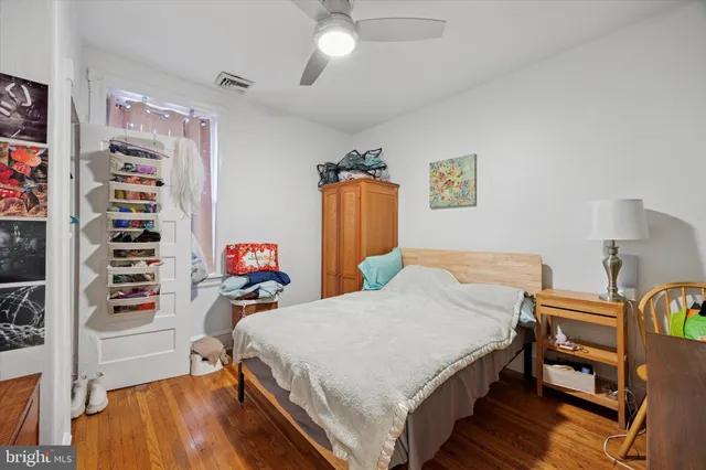 a bedroom with a bed closet and wooden floor
