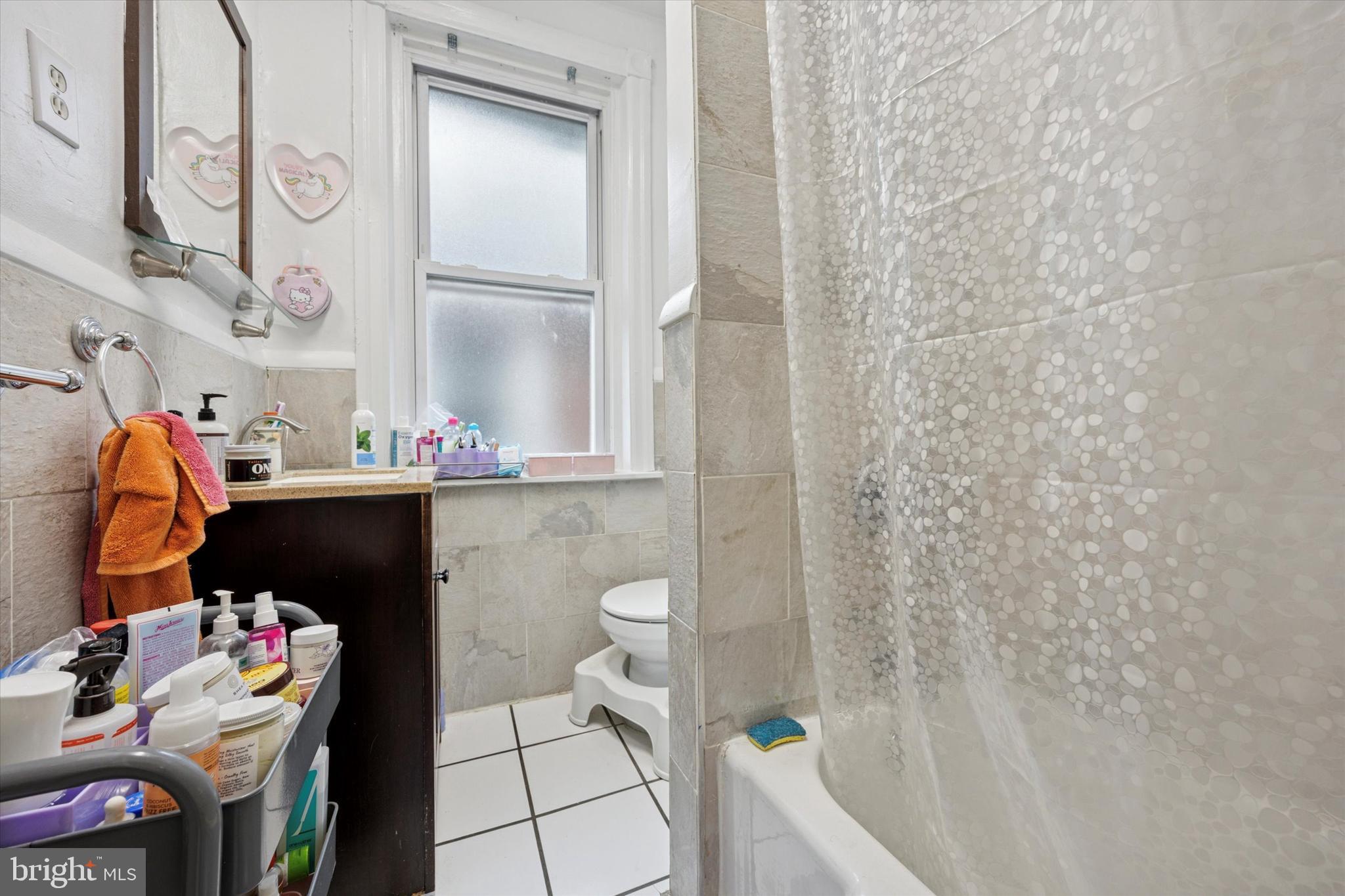 238 South 45th Street Philadelphia, PA 19104 - Photo 7 of 11 a bathroom with a sink a toilet and shower curtain